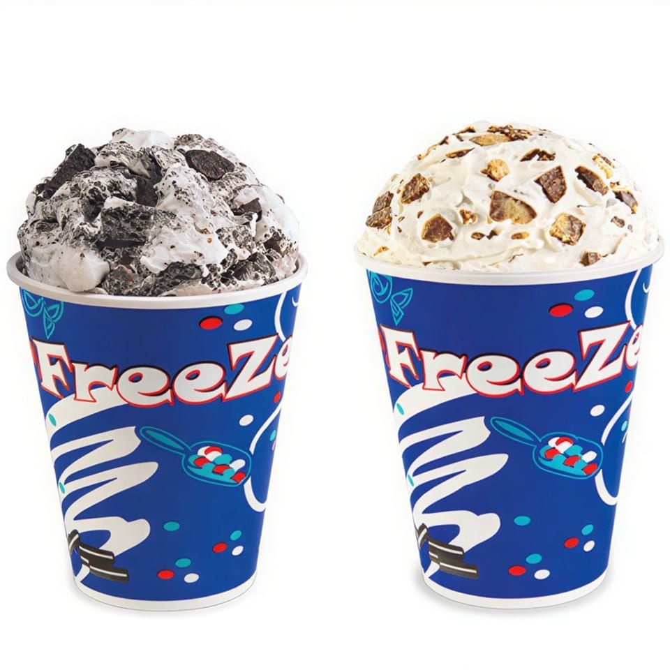 Two Freeze cups, one with cookies and cream, the other with peanut butter cup toppings.
